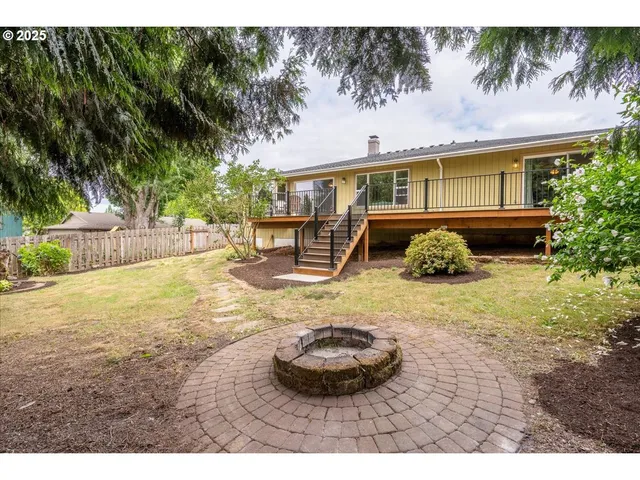 a backyard of a house with barbeque oven and trees