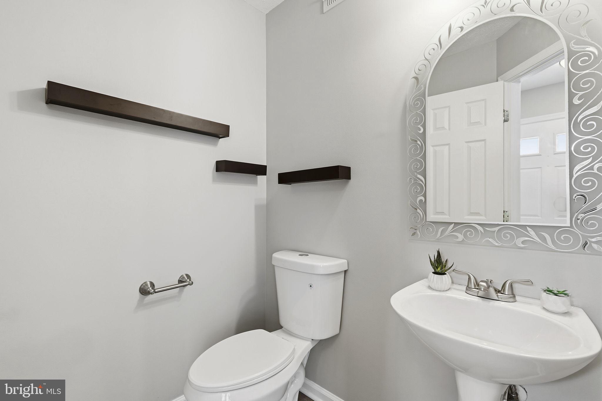 3172 Hidden Ridge Terrace Abingdon, MD 21009 - Photo 11 of 34 a bathroom with a toilet sink and mirror
