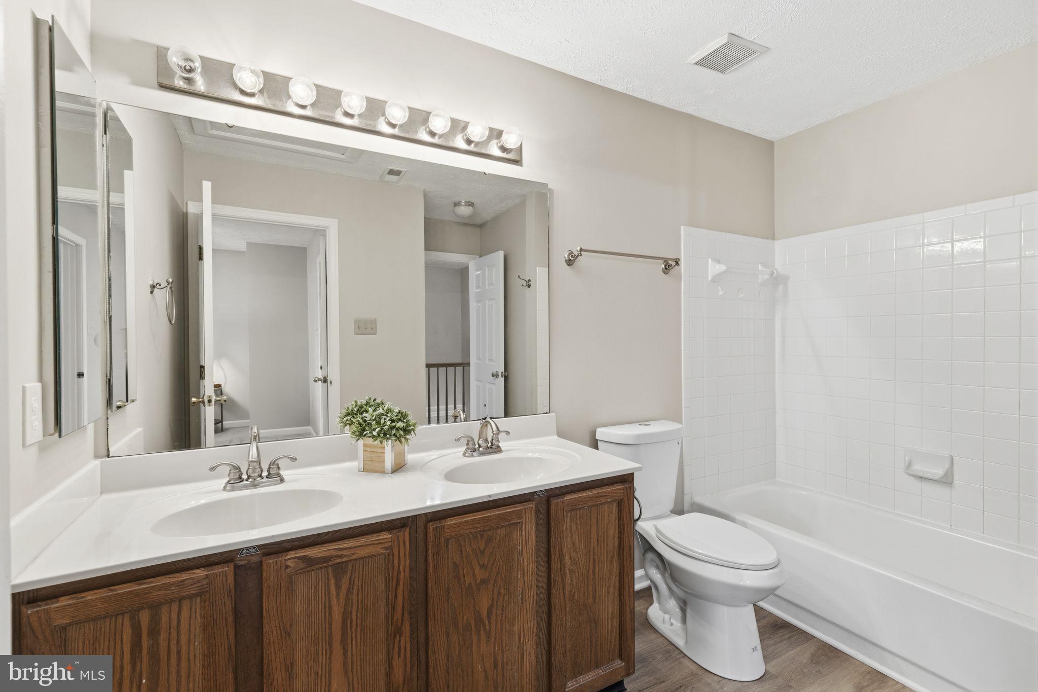 3172 Hidden Ridge Terrace Abingdon, MD 21009 - Photo 17 of 34 a bathroom with a double vanity sink toilet and shower