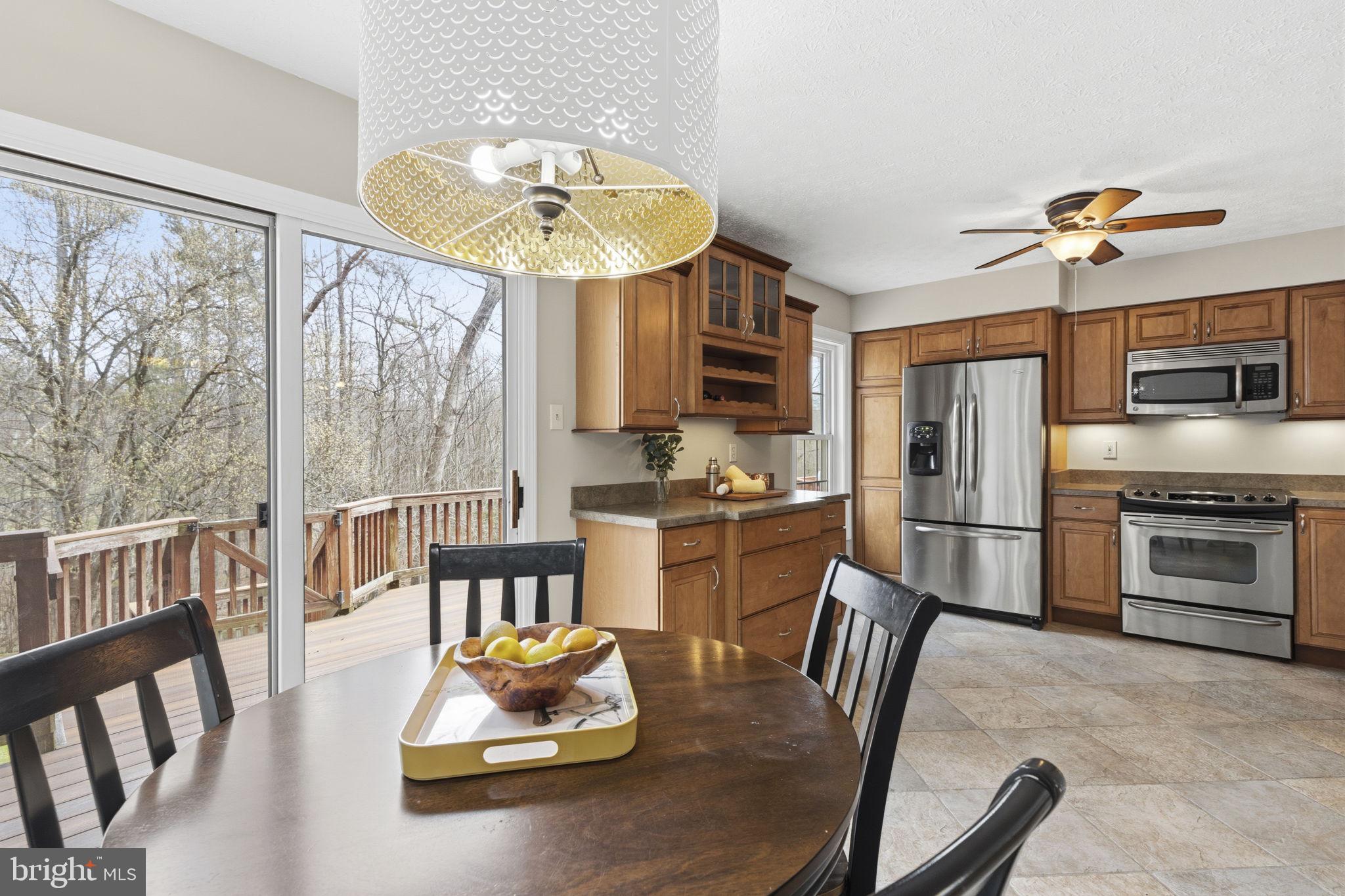 3172 Hidden Ridge Terrace Abingdon, MD 21009 - Photo 7 of 34 a kitchen with a table chairs microwave and cabinets