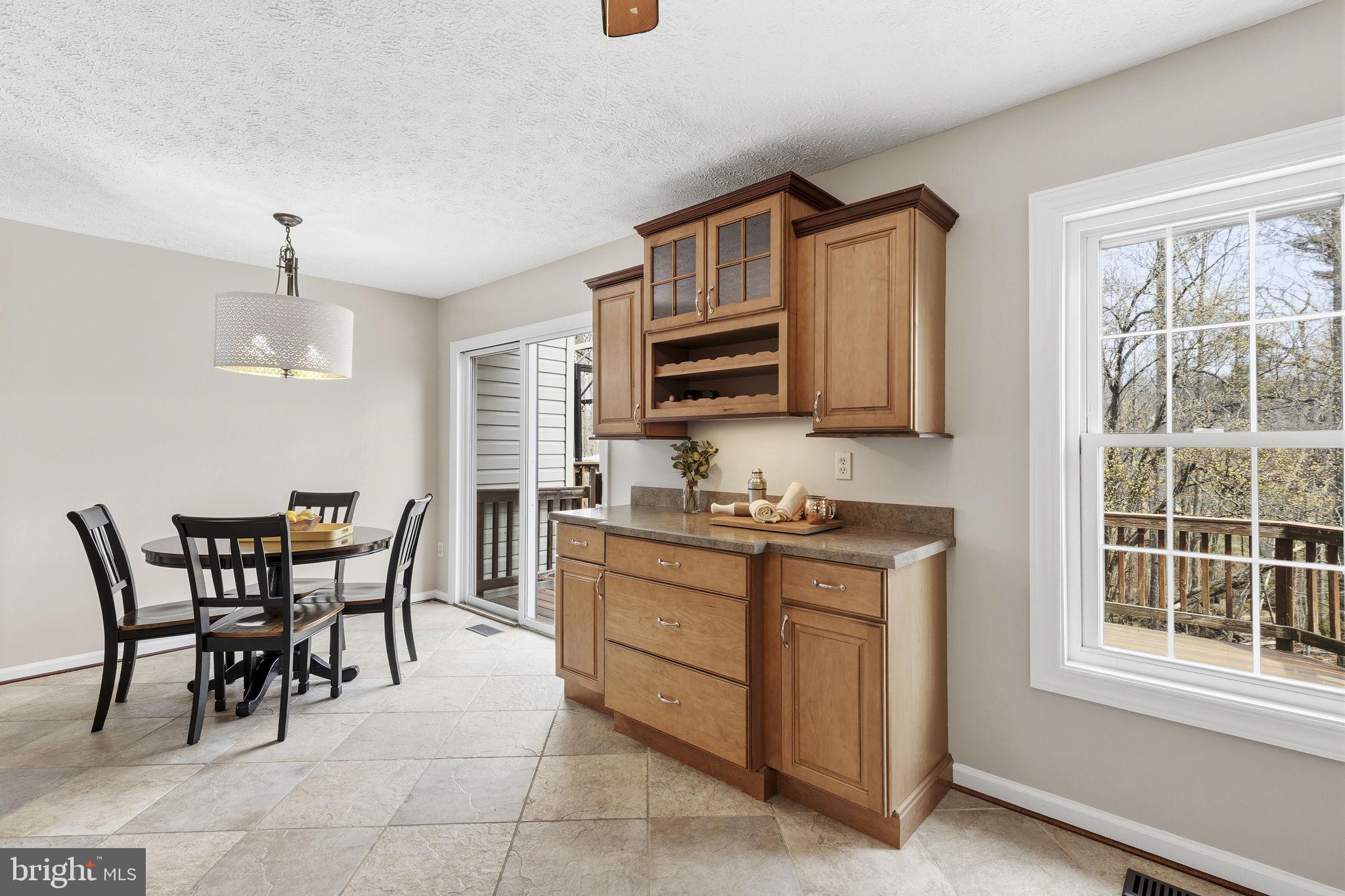 3172 Hidden Ridge Terrace Abingdon, MD 21009 - Photo 10 of 34 a kitchen with stainless steel appliances granite countertop a stove top oven a sink a dining table and chairs with wooden floor