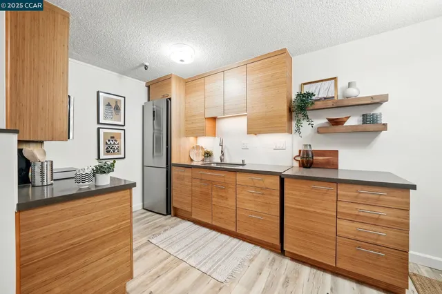 a kitchen with stainless steel appliances kitchen island granite countertop a sink cabinets and wooden floor
