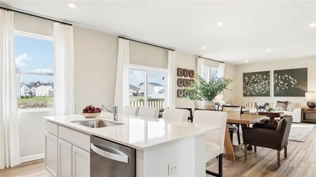 a kitchen with a table chairs and white cabinets