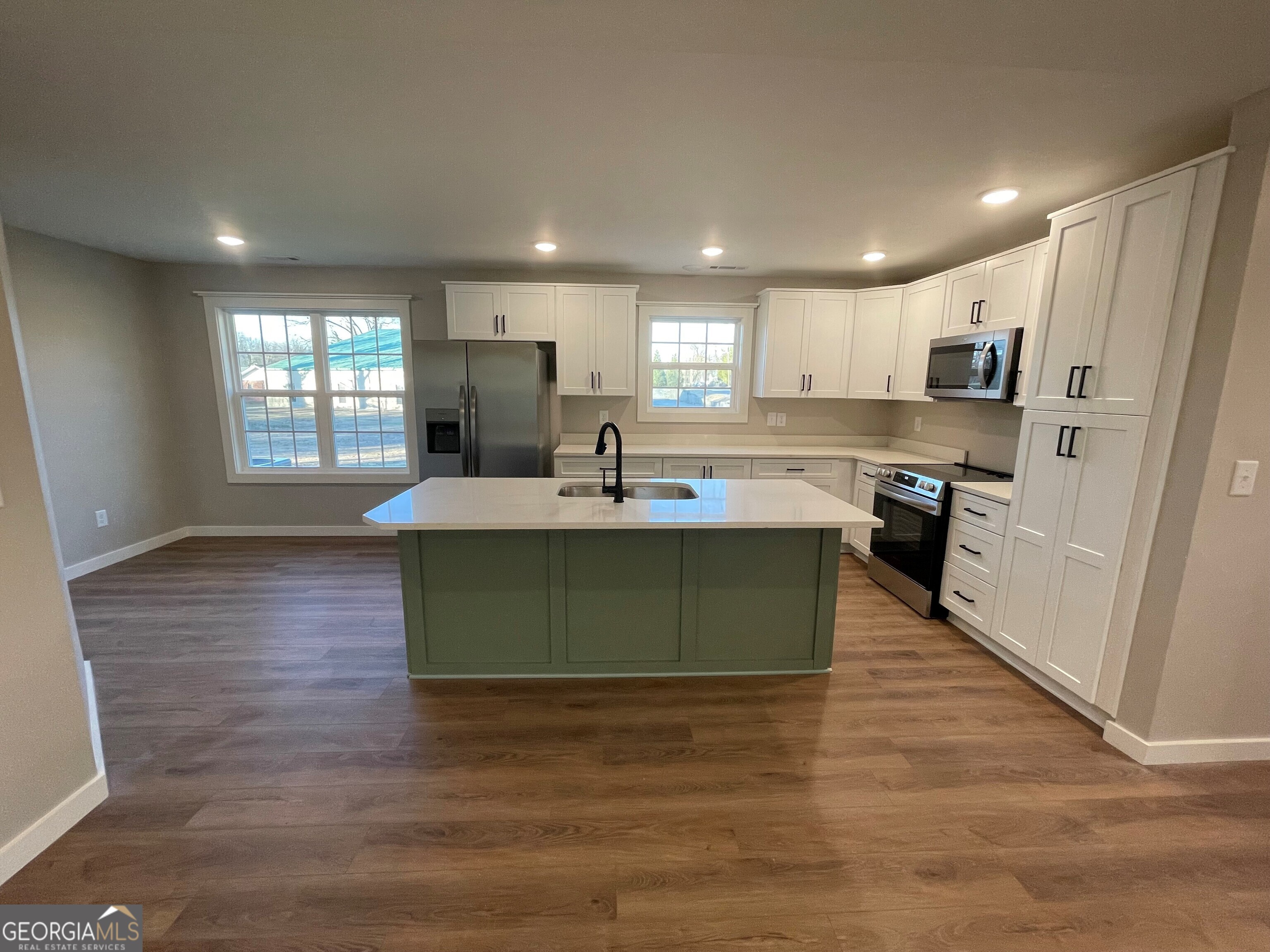 410 Hardy Avenue Southwest Rome, GA 30161 - Photo 19 of 36 a kitchen with kitchen island granite countertop a sink cabinets and wooden floor