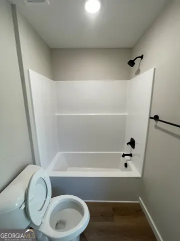 a bathroom with a toilet and a bathtub