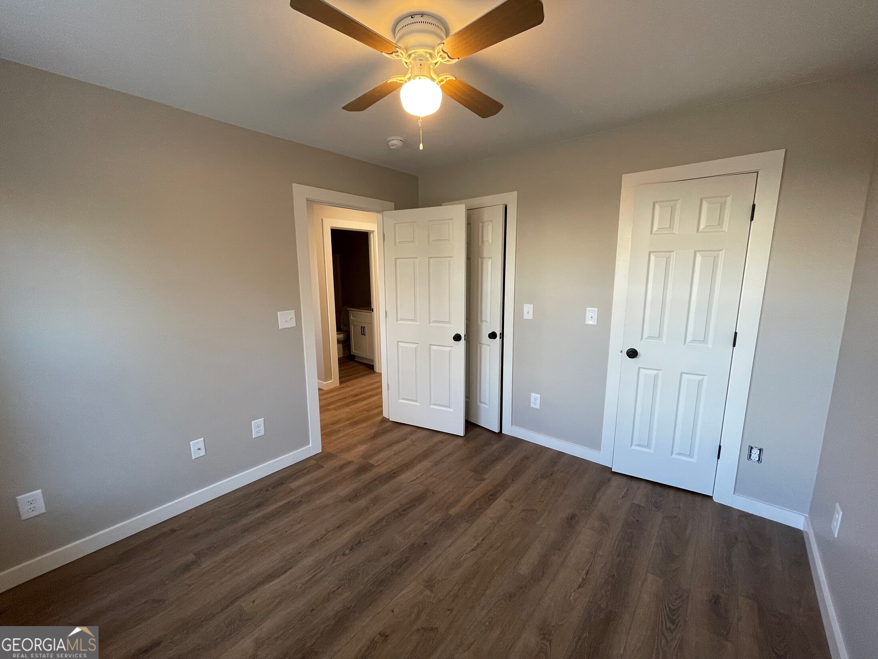 410 Hardy Avenue Southwest Rome, GA 30161 - Photo 7 of 36 an empty room with wooden floor and a ceiling fan