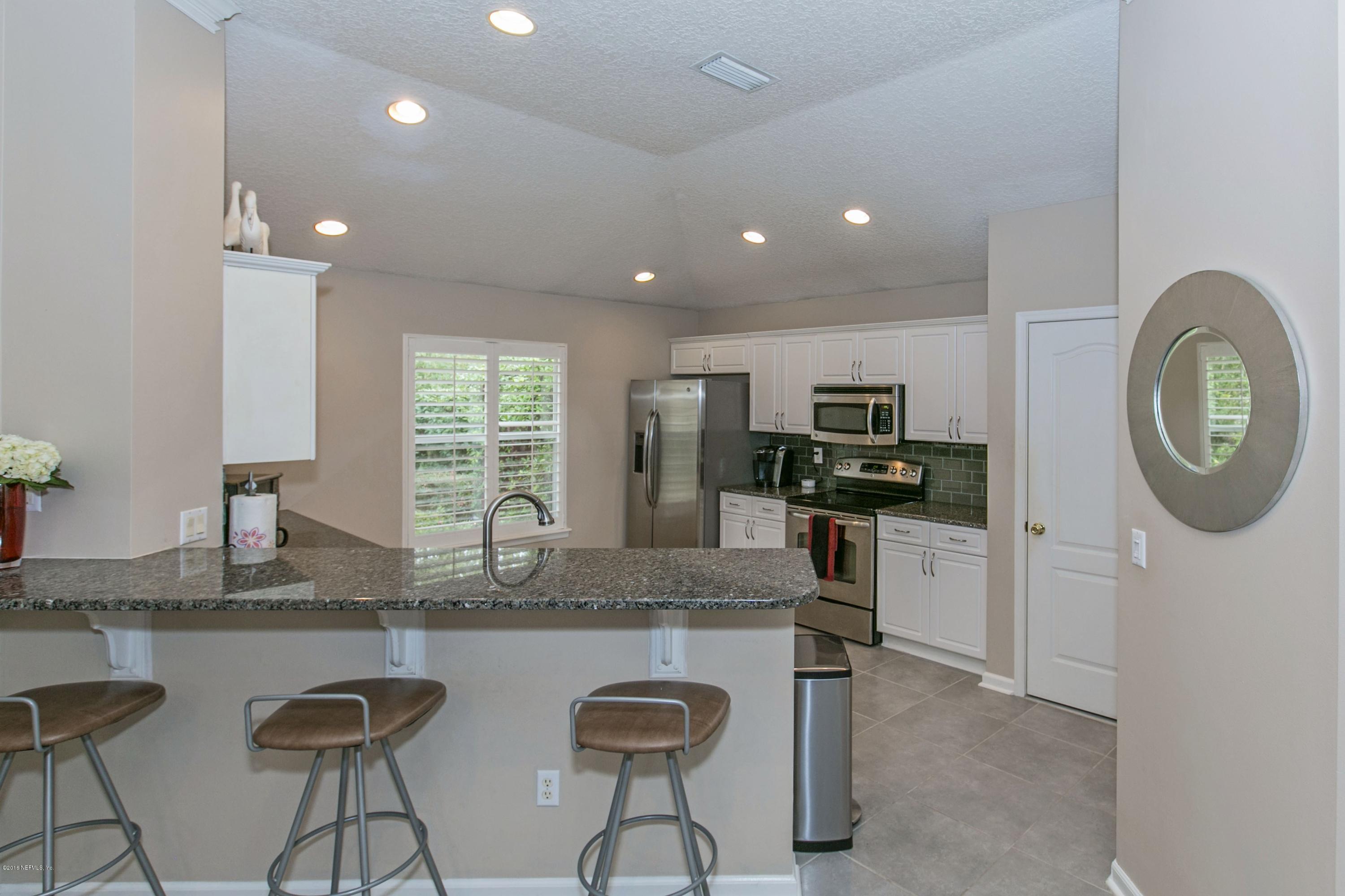445 Big Tree Road Ponte Vedra Beach, FL 32082 - Photo 6 of 23 a kitchen with stainless steel appliances granite countertop a sink a stove a refrigerator cabinets and chairs