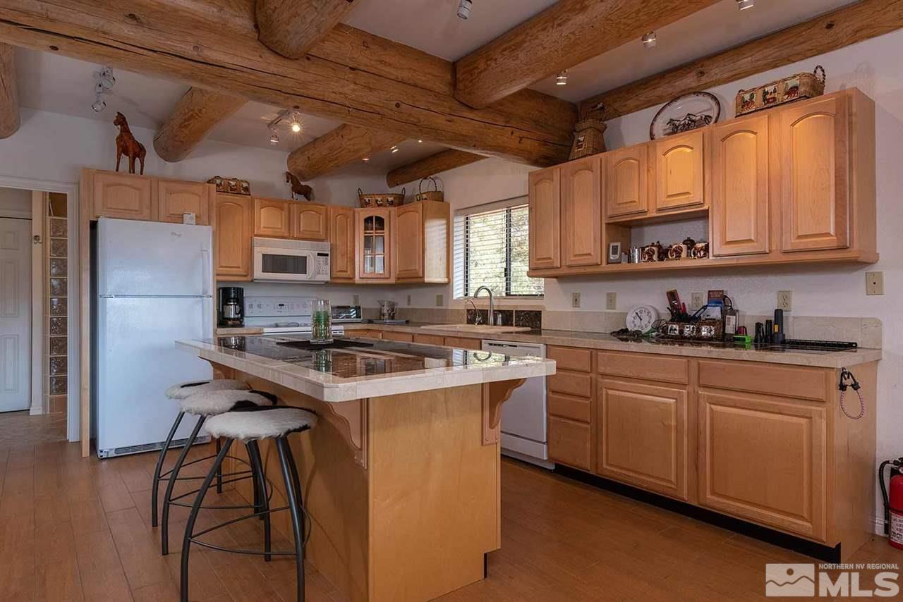 2441 Enterprise Road Reno, NV 89521 - Photo 4 of 25 a kitchen with stainless steel appliances granite countertop a stove a sink dishwasher a refrigerator and cabinets with wooden floor