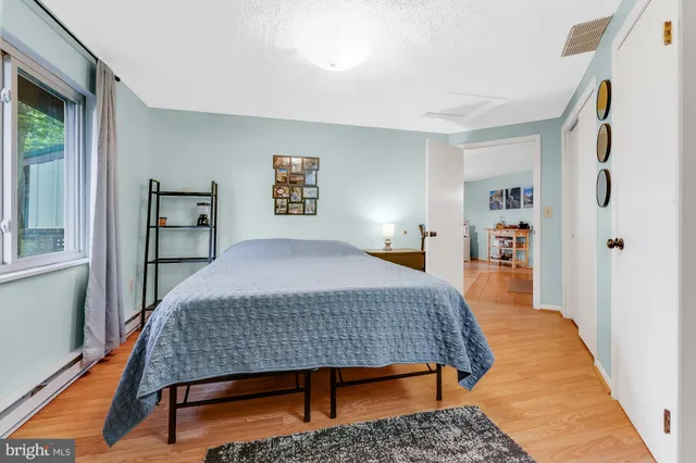 a bedroom with a bed and wooden floor