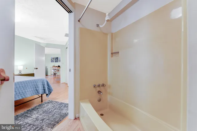 a bathroom with a tub shower and a sink