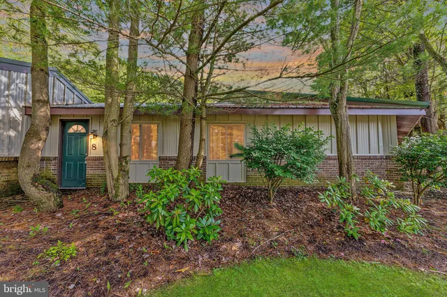 a view of a house with a yard and large tree