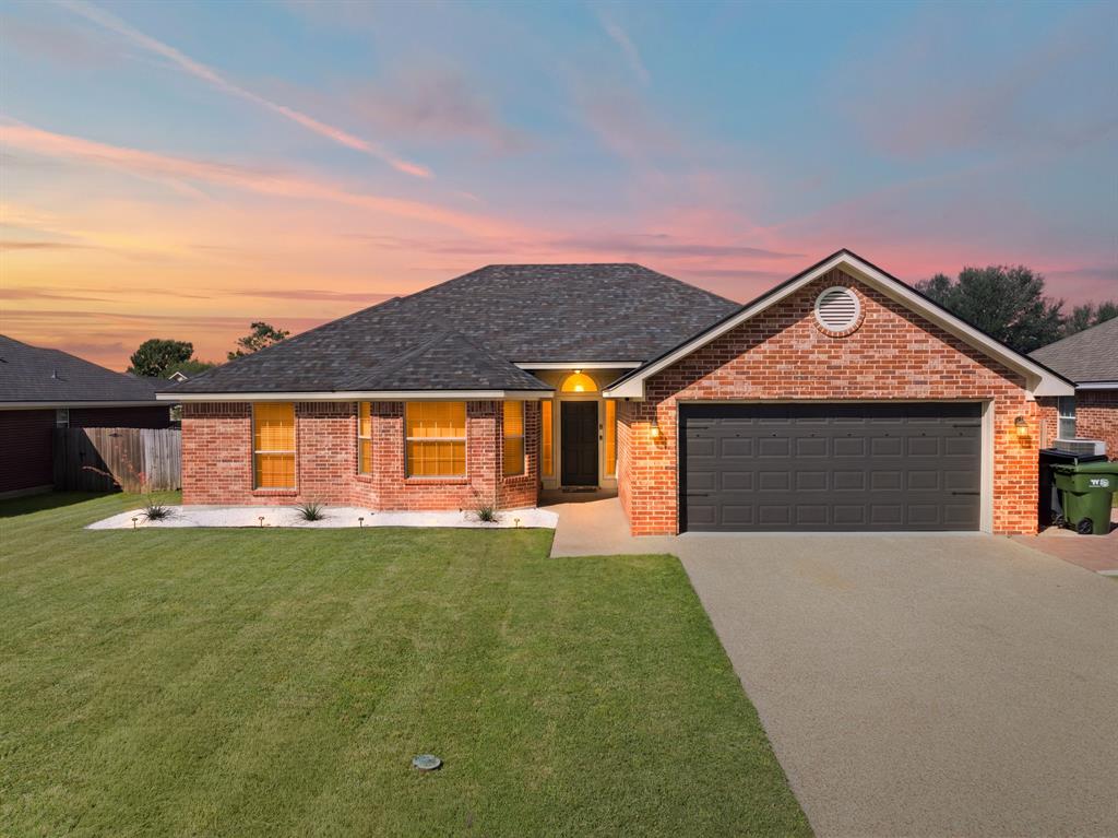 10512 Whitney Trace Drive Waco, TX 76708 - Photo 1 of 39 Brick exterior featuring a dark asphalt shingle roof and a two-car garage
