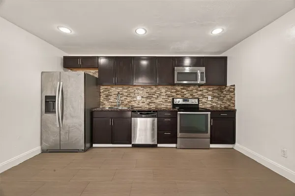 a large kitchen with a stove and a refrigerator