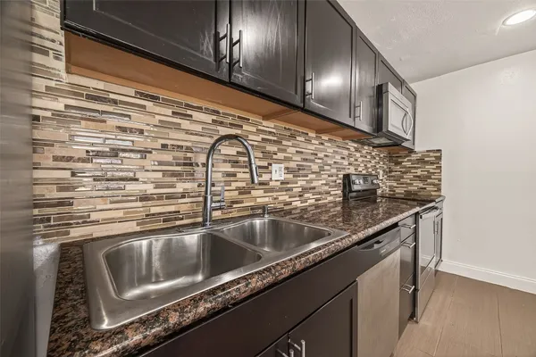 a close view of a sink a counter top space and cabinets