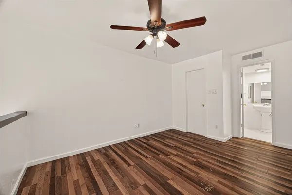 a view of room with wooden floor and fan