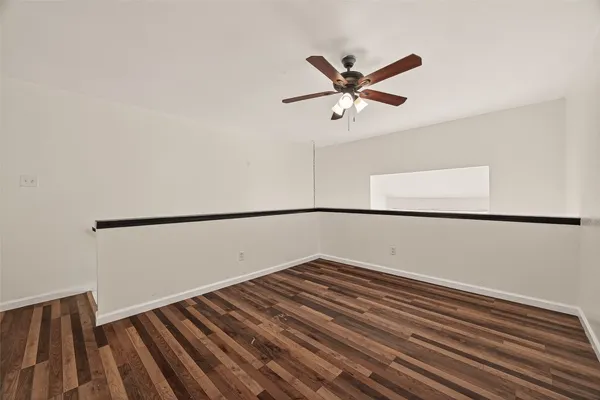 a view of a room with wooden floor and white walls
