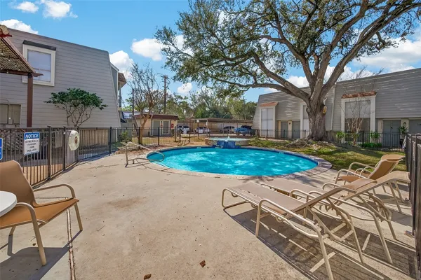 a view of a backyard with table and chairs with wooden fence and plants