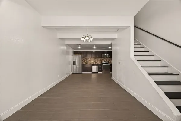 a view of a hallway with wooden floor and staircase