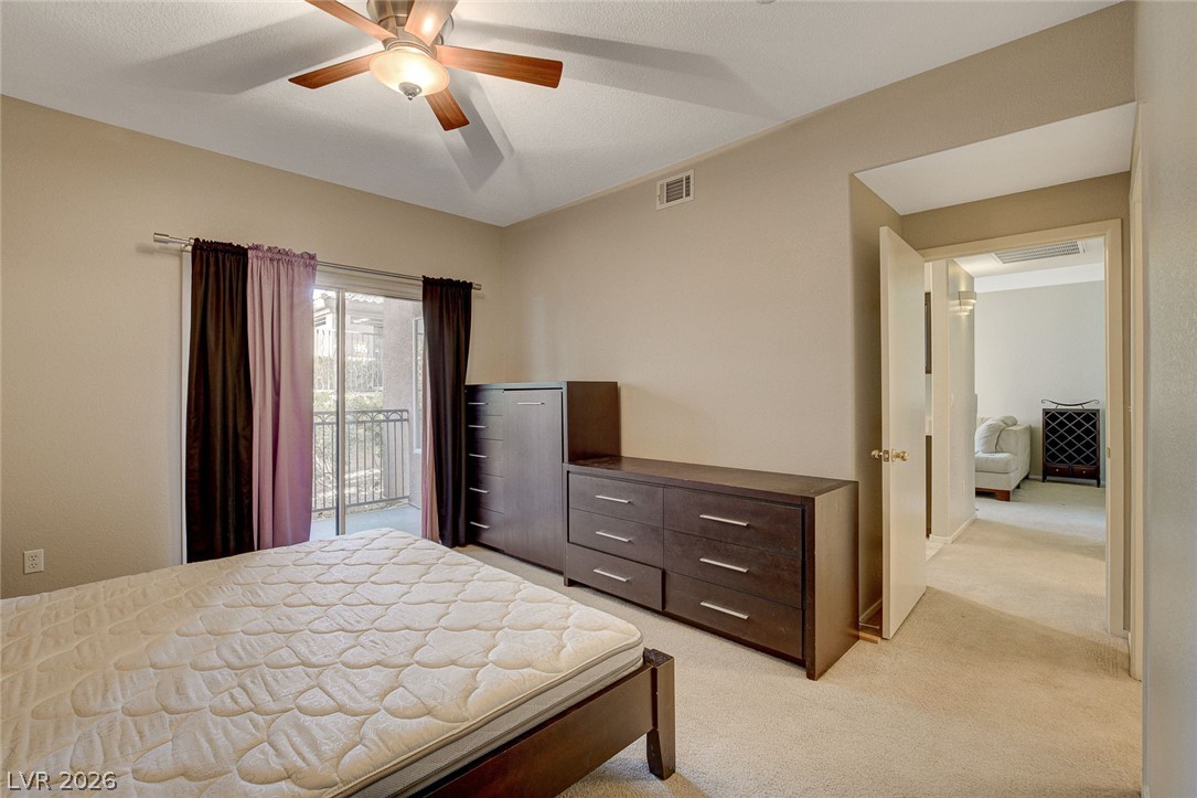 9050 West Warm Springs Road, Unit 1034 Las Vegas, NV 89148 - Photo 8 of 17 Restful bedroom retreat with a private balcony for serene outdoor moments.