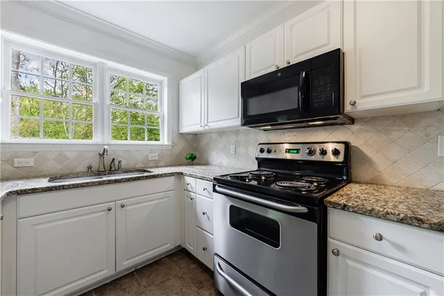 a kitchen with stainless steel appliances granite countertop a sink stove and cabinets