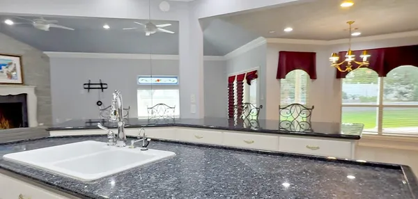 a bathroom with a granite countertop sink and a large mirror