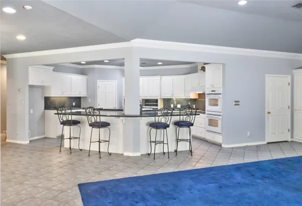 an open kitchen with white cabinets and stainless steel appliances