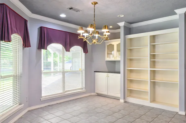 a view of a room with a chandelier and large windows