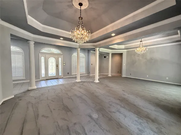 a view of a livingroom with a chandelier fan and windows