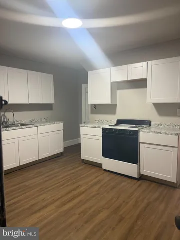 a kitchen with granite countertop white cabinets and white appliances