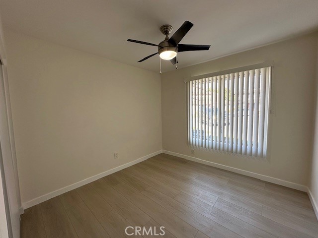 17061 Grove Circle, Unit A Huntington Beach, CA 92647 - Photo 8 of 30 an empty room with wooden floor fan and windows