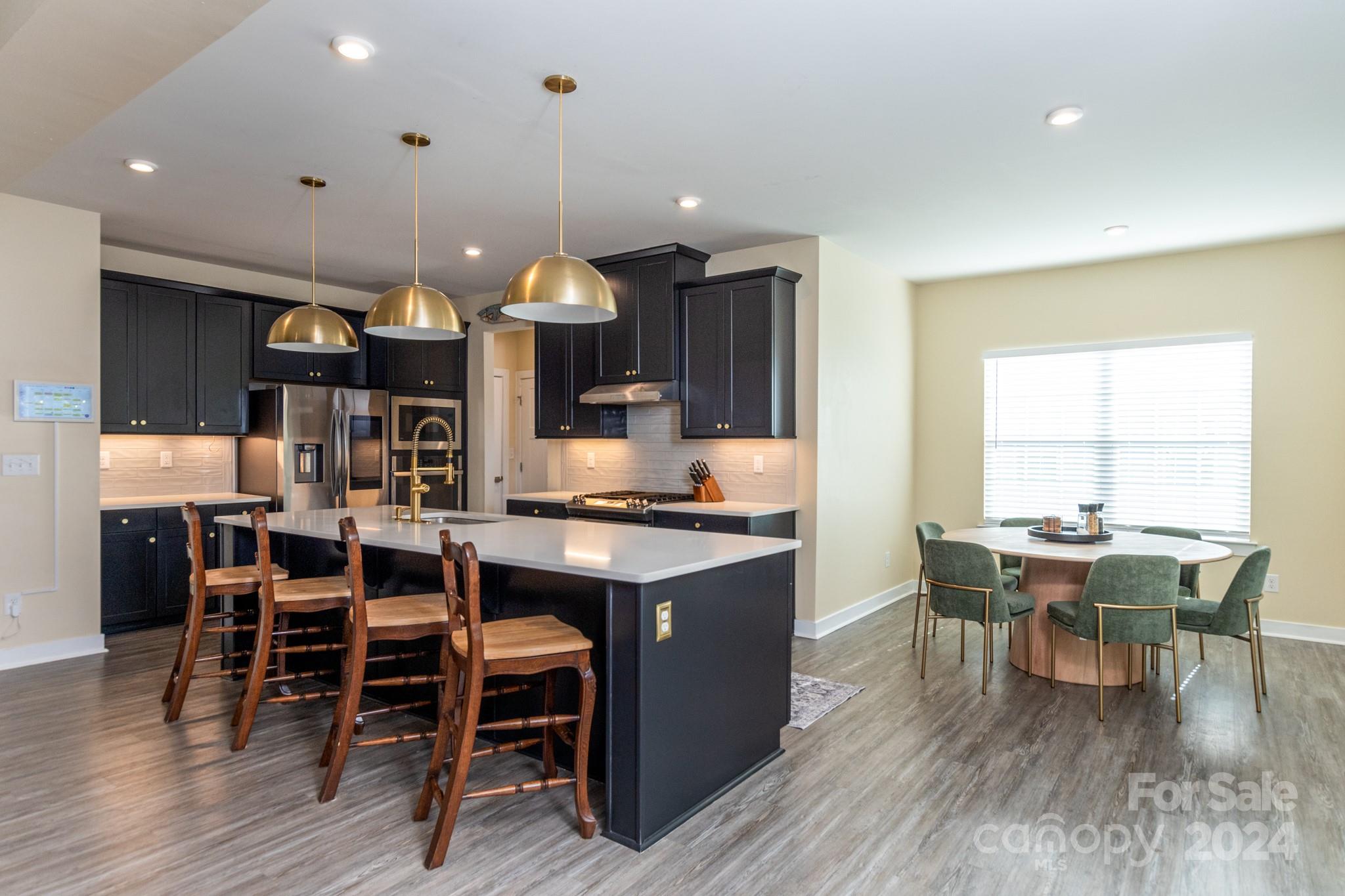 14306 Sunnyhill Grove Road Davidson, NC 28036 - Photo 12 of 35 a kitchen with a dining table chairs wooden floor dining table and chairs