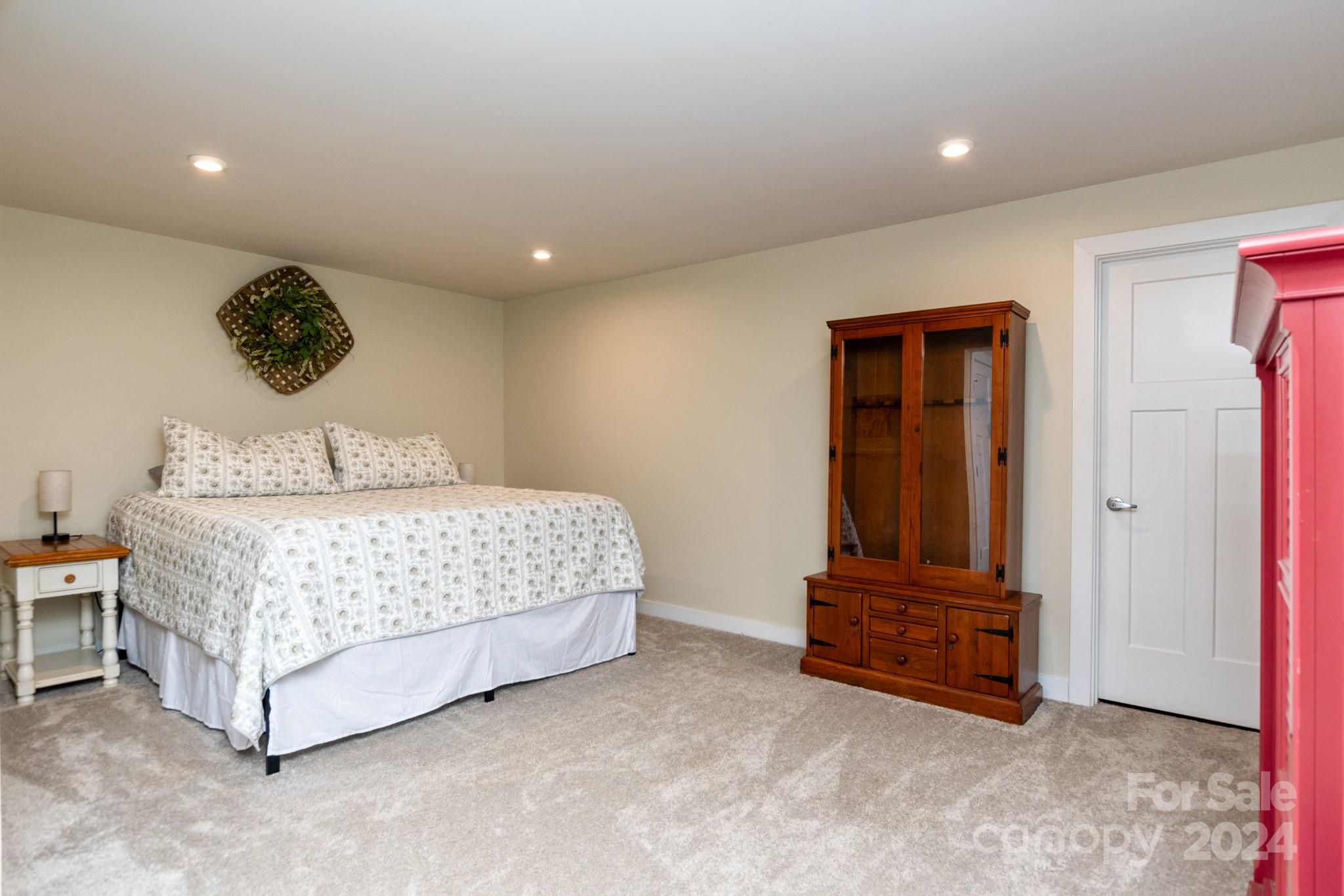 14306 Sunnyhill Grove Road Davidson, NC 28036 - Photo 26 of 35 a bedroom with a bed and a chandelier