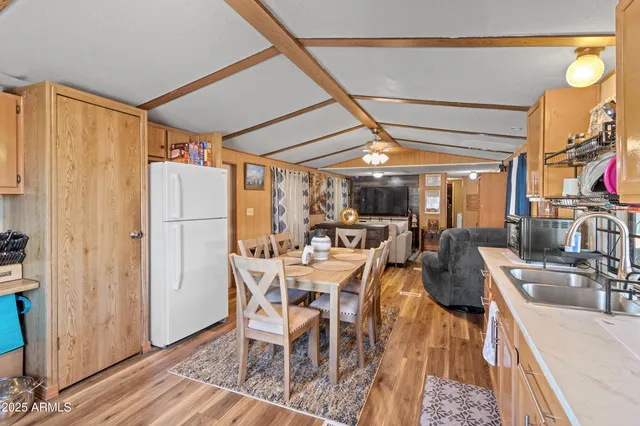 a dining room with stainless steel appliances granite countertop a table chairs and a refrigerator