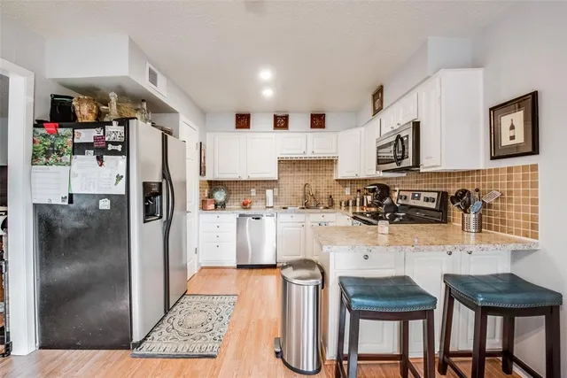a kitchen with granite countertop a sink a stove and cabinets