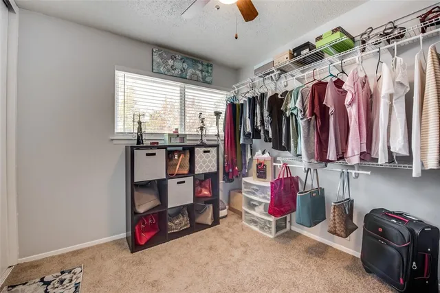 a view of walk in closet with clothes and shoes