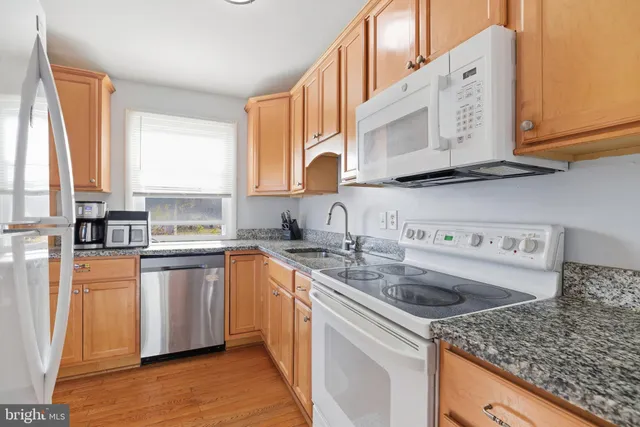 a kitchen with stainless steel appliances granite countertop a sink stove and cabinets