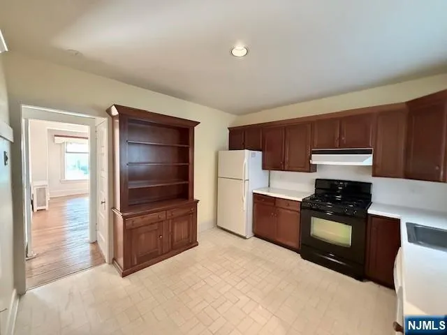 a kitchen with stainless steel appliances a stove a refrigerator and a stove