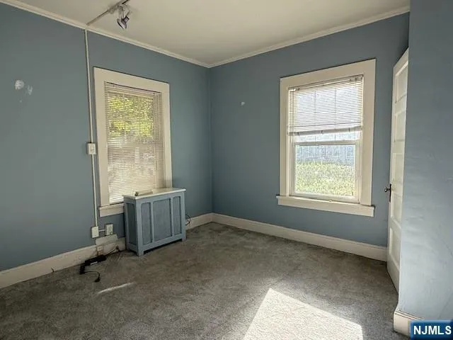 an empty room with a window and a dresser