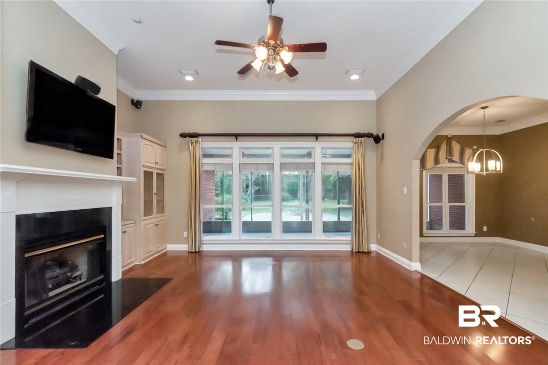 8837 Dawes Lake Road South Mobile, AL 36619 - Photo 7 of 44 Unfurnished living room featuring hardwood / wood-style floors, ceiling fan with notable chandelier, and crown molding