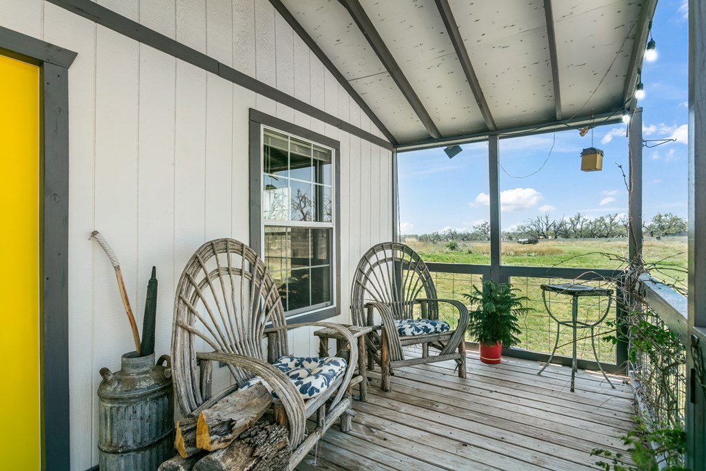 3527 Old Harper Road Fredericksburg, TX 78624 - Photo 18 of 41 a view of a balcony with chairs and wooden floor
