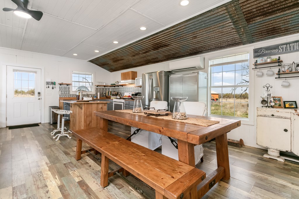 3527 Old Harper Road Fredericksburg, TX 78624 - Photo 7 of 41 a dining hall with stainless steel appliances kitchen island granite countertop a table chairs and a wooden floor