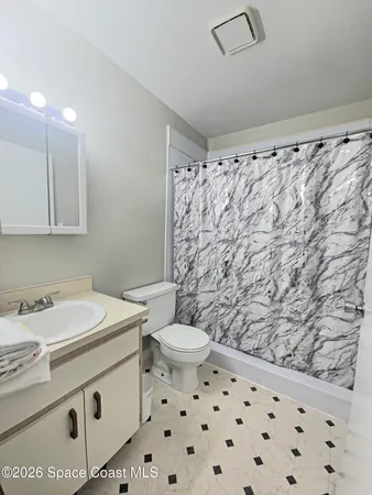 a bathroom with a sink a toilet and a shower