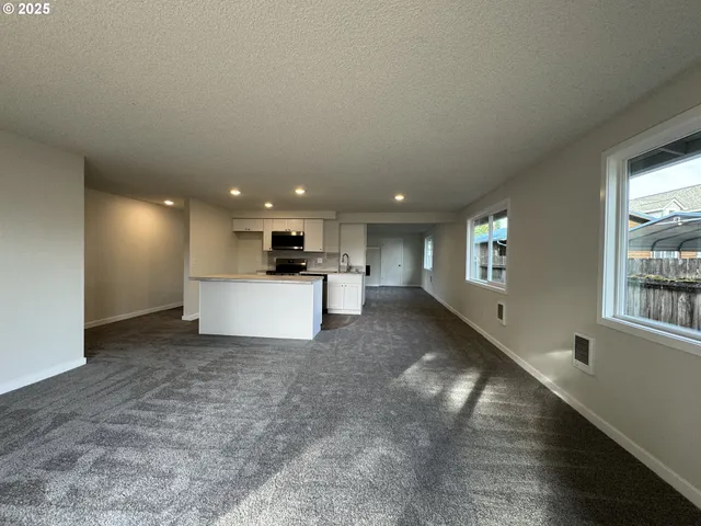 a large kitchen with kitchen island a sink a stove and a refrigerator