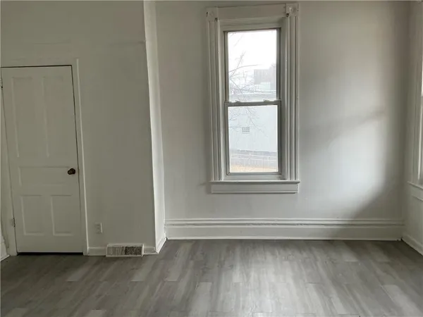 a view of a room with wooden floor and window