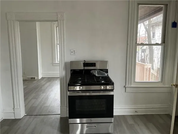 a kitchen with wooden floor and a stove top oven