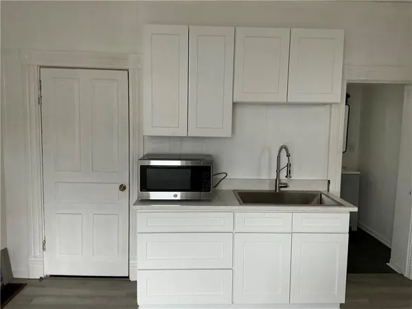 a kitchen with stainless steel appliances granite countertop white cabinets and a sink