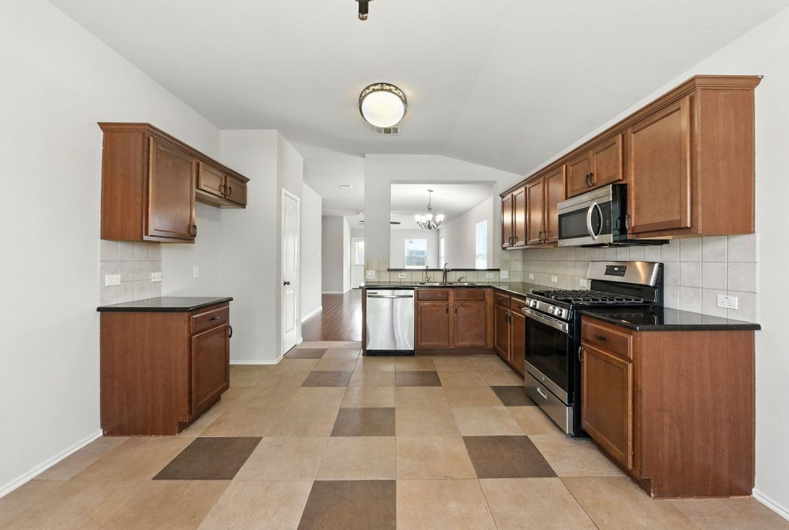 2840 Hearthsong Loop Round Rock, TX 78665 - Photo 12 of 39 a kitchen with stainless steel appliances granite countertop a refrigerator stove top oven and sink