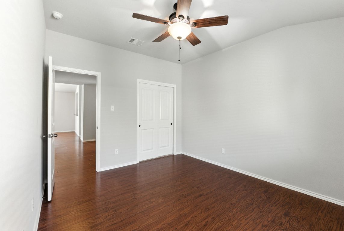 2840 Hearthsong Loop Round Rock, TX 78665 - Photo 17 of 39 an empty room with wooden floor a ceiling fan and closet