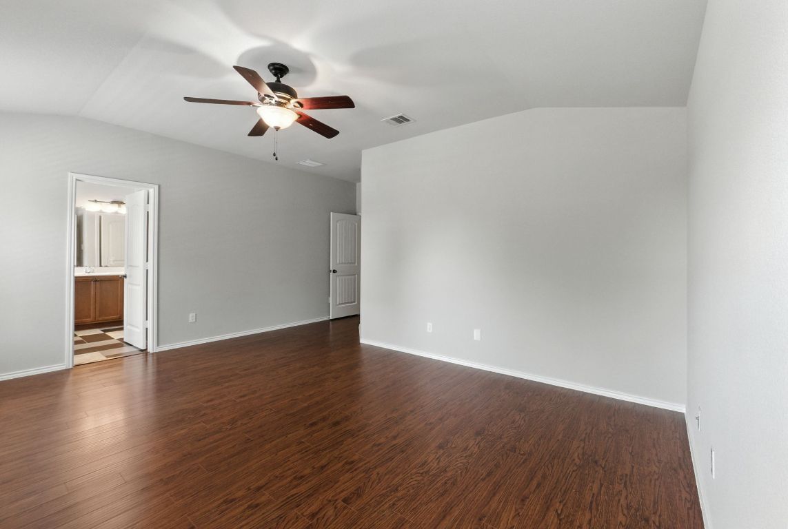 2840 Hearthsong Loop Round Rock, TX 78665 - Photo 27 of 39 a view of an empty room with wooden floor and a ceiling fan