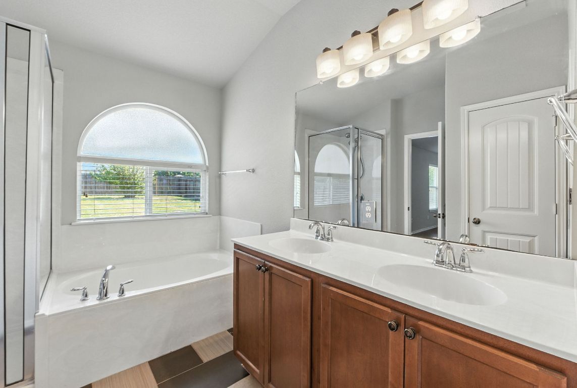 2840 Hearthsong Loop Round Rock, TX 78665 - Photo 30 of 39 a bathroom with a tub a sink and a large mirror